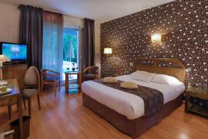 una camera d'albergo con un grande letto e un tavolo e una camera di Logis Burnel Et La Cle Des Champs a Rouvres-en-Xaintois