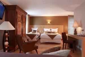 Habitación de hotel con 2 camas y escritorio en Logis Burnel Et La Cle Des Champs en Rouvres-en-Xaintois