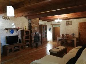 a living room with a television and a dining room at Finca San Diego, villa entera para ti in Vallonga
