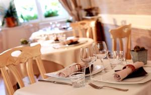 - une table avec des verres à vin et des serviettes dans l'établissement Logis Burnel Et La Cle Des Champs, à Rouvres-en-Xaintois