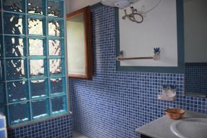 een blauw betegelde badkamer met een wastafel en een spiegel bij Molino El Mastral in Tarifa +57 foto's