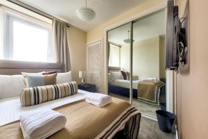 1 dormitorio con 1 cama grande y espejo en No.5 Serviced Apartment, en Glasgow