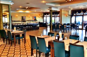 a dining room with tables and chairs in a restaurant at Family Resort Hotel in Selimpasa