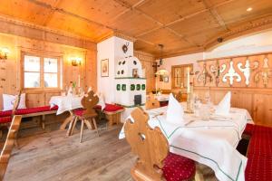 a restaurant with wooden walls and tables and chairs at Landhotel Römerhof in Dorfgastein