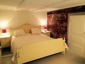 1 dormitorio con 1 cama blanca grande y 2 lámparas en Malistorpets Rosor en Varberg