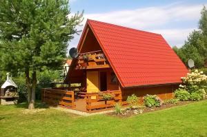 a log cabin with a red roof at morska chata in Lubiatowo
