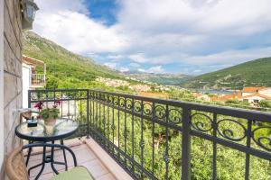 einen Balkon mit einem Tisch und Stühlen sowie Aussicht in der Unterkunft Tranquility and Nature in 4 Bedroom with Sea View in Mokošica
