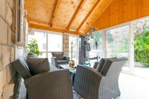 eine abgeschirmte Veranda mit Stühlen und einem Tisch in der Unterkunft Tranquility and Nature in 4 Bedroom with Sea View in Mokošica