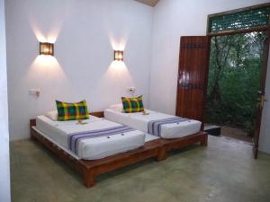 two twin beds in a room with a window at Grand freedom in Sigiriya +92 photos