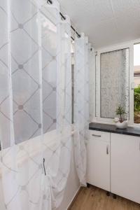 a bathroom with a shower with white walls at White Rose Apartment in Dubrovnik