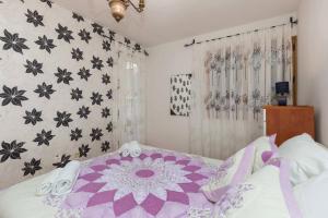 a bedroom with a purple and black patterned wall at White Rose Apartment in Dubrovnik
