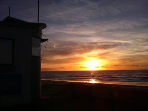 um pôr do sol na praia com o oceano em La Timonerie - La Caraque 35, vue mer et dunes classé 2 étoiles em Fort-Mahon-Plage