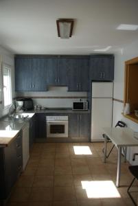 コニル・デ・ラ・フロンテーラにあるApartamento Mirador de Conilの青いキャビネットとテーブル付きのキッチンが備わります。