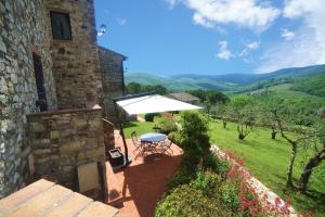 a patio with a table and a white umbrella at Casalta Di Pesa in Siena