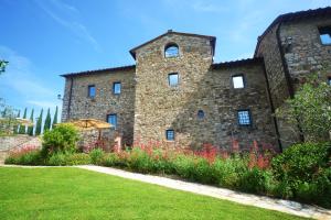 a large stone building with flowers in front of it at Casalta Di Pesa in Siena