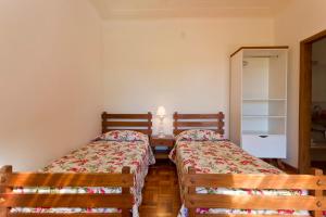 1 dormitorio con 2 camas y espejo en Fazenda Santa Teresa Hotel, en Bocaina