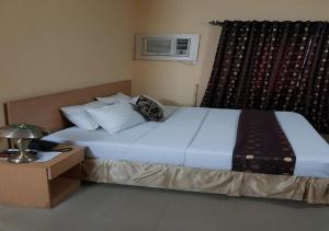 um quarto com uma cama grande e uma janela em Citilodge Hotel & Conference Centre em Abuja