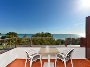 balcón con mesa, sillas y vistas al océano en Hotel Fuerte Conil-Resort en Conil de la Frontera