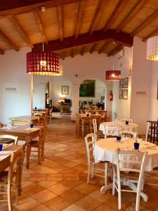 un comedor con mesas, sillas y lámparas de araña en Agriturismo al Colle, en Bertinoro