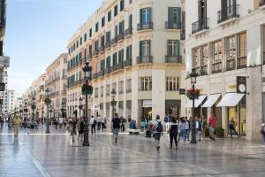 a group of people walking down a city street at Petit Palace Plaza Málaga in Málaga