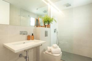 La salle de bains est pourvue d'un lavabo, de toilettes et d'un miroir. dans l'établissement Sea Breeze Apartments, à Cala Millor