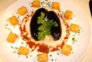 eine weiße Platte mit einer Mahlzeit mit schwarzer Aubergine und Soße in der Unterkunft Gasthof-Landhotel-Metzgerei Zum Stern in Rüdenau