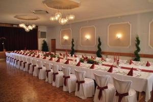 einen großen Bankettsaal mit weißen Tischen und Stühlen in der Unterkunft Gasthof-Landhotel-Metzgerei Zum Stern in Rüdenau