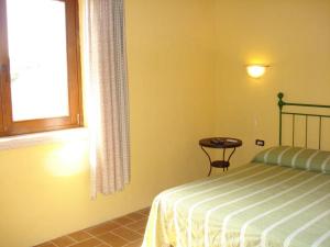 a bedroom with a bed and a window and a table at Agriturismo Terre di Musignano in Canino