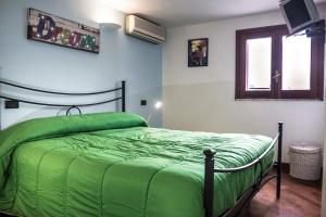 a green bed in a room with a window at Dream House Duomo Catania in Catania