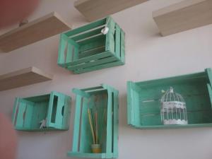 パキーノにあるle cassetteの緑のキャビネットと鳥かごの壁