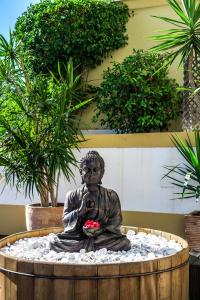 a statue of a person sitting in a meditation bowl at Vale d'El Rei Hotel & Villas in Carvoeiro