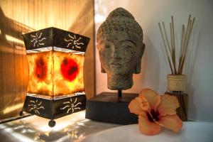 a statue of a head next to a lamp and a flower at Vale d'El Rei Hotel & Villas in Carvoeiro
