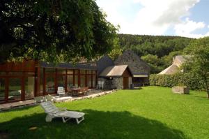 une cour avec un banc et une maison dans l'établissement Hôtel/Restaurant à la Ferme, à Ferrières