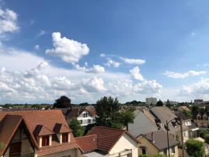 eine Gruppe von Häusern in einer Stadt unter einem wolkigen Himmel in der Unterkunft Sleep in Paris - Pontault in Pontault-Combault