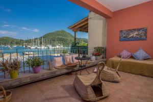 a balcony with a bed and chairs and a view of the water at Blue Seaview Apartment 75 sqm on Nydri Coast in Nydri