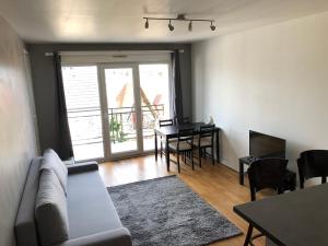 ein Wohnzimmer mit einem Sofa und einem Tisch in der Unterkunft Sleep in Paris - Pontault in Pontault-Combault