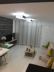 ein Wohnzimmer mit Sofa und Tisch in der Unterkunft Boulevard La Zenia Villa in Playa Flamenca