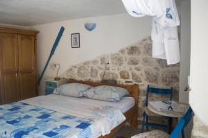 - une chambre avec un lit et un mur en pierre dans l'établissement Apartments Subotic, à Risan