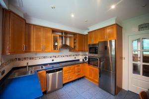 a kitchen with wooden cabinets and a stainless steel refrigerator at Calle Río de la Pila in Santander