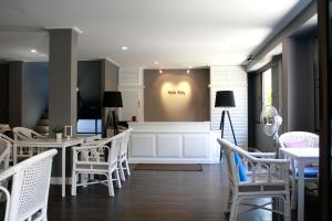 a dining room with white chairs and tables at Hotel Alley in Hua Hin