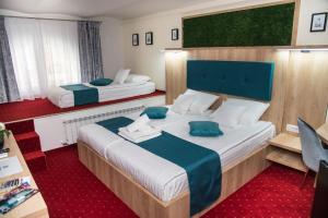 2 camas en una habitación de hotel con alfombra roja en Brekner Rooms, en Sibiu