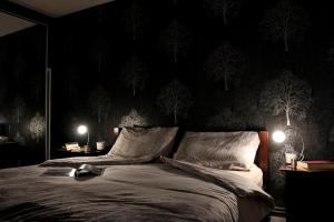 a bedroom with a bed with black walls and trees on the wall at Angel in London