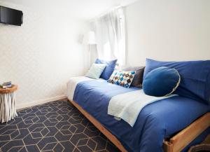 um quarto com uma cama com lençóis e almofadas azuis em Casa com Alma Portuguesa @ Alfama Studio em Lisboa