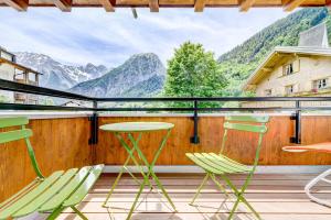 a balcony with chairs and a table and mountains at Hotel Lün in Brand