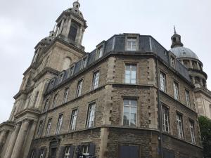 un vecchio edificio di mattoni con una torre sopra di Comme à la maison a Boulogne-sur-Mer