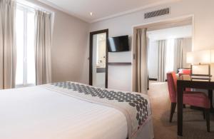 a hotel room with a bed and a desk at Montfleuri in Paris