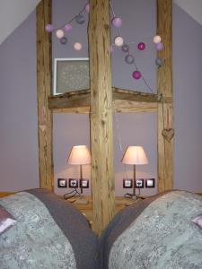 una camera con letto in legno e 2 lampade di La Vallée a Le Mont-Dore