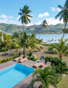 un complejo con piscina y palmeras en Surf Tropical Villa Seascape, en Isla de Cerf