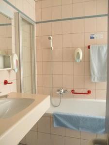 ein Badezimmer mit einer Dusche, einem Waschbecken und einer Badewanne in der Unterkunft Hôtel du Port - Free Parking - Breakfast included in Estavayer-le-Lac