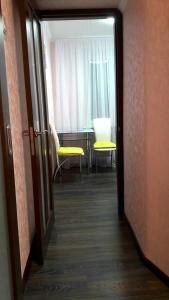 a hallway with two chairs and a table and a window at Apartments in the Center of the city in Dnipro